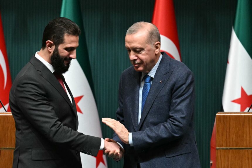Turkish President Recep Tayyip Erdogan (R) and Syria's interim president Ahmed al-Sharaa shake hands during a joint press conference following their meeting at the Presidential Palace in Ankara, on February 4, 2025. Syria's interim president is in Turkey for talks with the country's leader after flying in from Saudi Arabia, where he was seeking help from wealthy Gulf countries to finance the reconstruction of his war-ravaged nation and revive its economy, as part of his second international trip since ousting the former Syrian president. (Photo by OZAN KOSE / AFP)