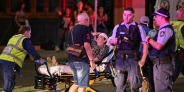 Health workers move a woman on a stretcher to an ambulance after a shooting incident at Bondi Beach in Sydney on December 14, 2025. Australian police said two people were in custody following reports of multiple gunshots on December 14 at Sydney's famed Bondi Beach, urging the public to take shelter. (Photo by Saeed KHAN / AFP)