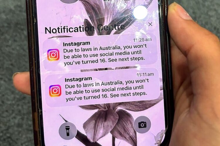 A teenager holds a mobile phone displaying a message from social media platform Instagram after the account was locked for age verification in Sydney on December 9, 2025. Australia will ban young teenagers from social media on December 10, 2025, launching a world-first crackdown designed to unglue children from addictive scrolling on the likes of Facebook, Instagram and TikTok. (Photo by AFP)