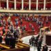 Members of Parliament and members of French government stand in tribute to French journalist Christophe Gleizes before a session of questions to the government at The National Assembly, France's parliament lower house in Paris on February 3, 2026. Gleizes was arrested in May 2024 while travelling to northeastern Algeria's Kabylia region to write about the country's most decorated football club, Jeunesse Sportive de Kabylie. (Photo by Ludovic MARIN / AFP)
