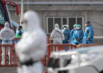 Passengers wearing a blue protective suits board a military bus after being evacuated from the Dutch flagged hantavirus-stricken cruise ship MV Hondius at the industrial port of Granadilla de Abona on the island of Tenerife in Spain's Canary Islands on May 10, 2026. Repatriation flights for the nearly 150 passengers onboard the ship hit by a deadly hantavirus outbreak began as passengers were transferred to shore on smaller vessels then by bus to the airport to be flown home after weeks at sea. (Photo by JORGE GUERRERO / AFP)